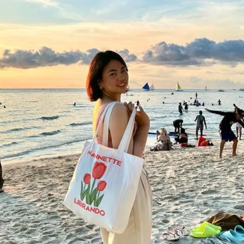 Portrait of the founder, standing on a beach at sunset.